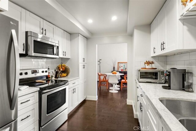 930 N Wetherly Dr Unit 201, West Hollywood, CA 90069 - kitchen with appliances with stainless steel finishes, recessed lighting, white cabinets, light stone countertops, and backsplash