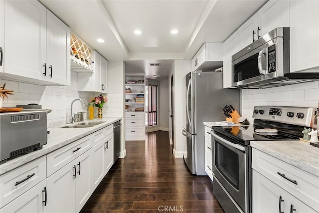 930 N Wetherly Dr Unit 201, West Hollywood, CA 90069 - kitchen featuring appliances with stainless steel finishes, dark wood finished floors, white cabinetry, backsplash, and recessed lighting