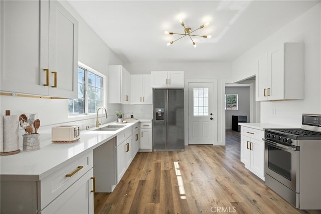 594 W 10th St, San Bernardino, CA 92410 - kitchen with stainless steel range with gas stovetop, refrigerator with ice dispenser, a chandelier, and healthy amount of natural light