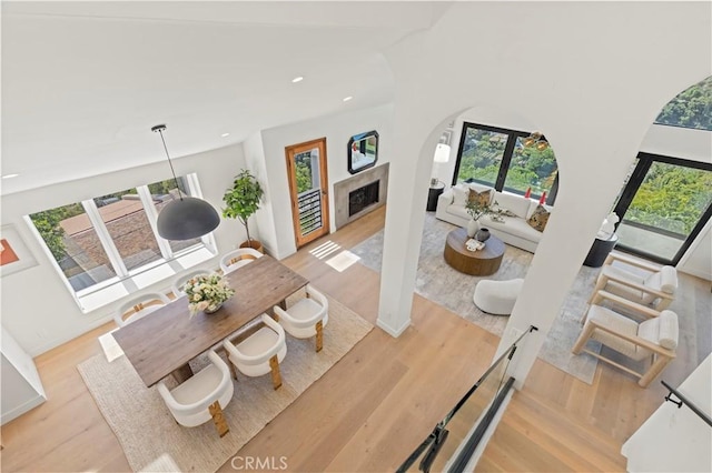 8280 Grand View Dr, Los Angeles, CA 90046 - dining area with wood finished floors, recessed lighting, a fireplace, and arched walkways