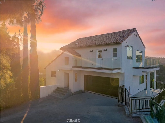 8280 Grand View Dr, Los Angeles, CA 90046 - mediterranean / spanish house featuring a balcony, stucco siding, a garage, driveway, and a tiled roof
