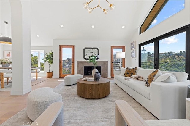 8280 Grand View Dr, Los Angeles, CA 90046 - living room featuring recessed lighting, a high end fireplace, a chandelier, high vaulted ceiling, and light wood-style floors