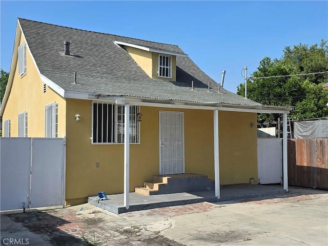 123 E Gage Ave, Los Angeles, CA 90003 - rear view of property featuring roof with shingles, stucco siding, and a patio