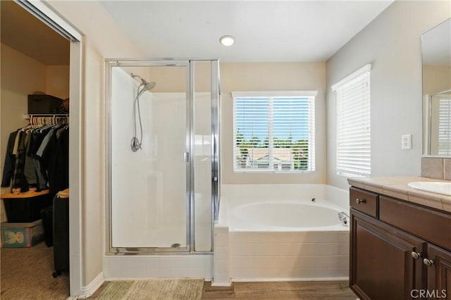 31258 Shadow Ridge Dr, Menifee, CA 92584 - full bathroom featuring a shower stall, vanity, a garden tub, wood finished floors, and a walk in closet