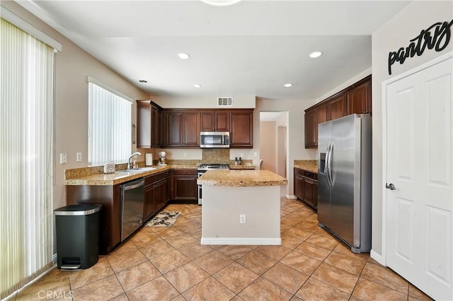 31258 Shadow Ridge Dr, Menifee, CA 92584 - kitchen with appliances with stainless steel finishes, a center island, light tile patterned floors, dark brown cabinets, and recessed lighting