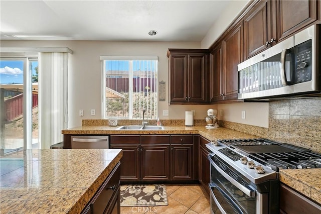 31258 Shadow Ridge Dr, Menifee, CA 92584 - kitchen with appliances with stainless steel finishes, plenty of natural light, light tile patterned floors, and dark brown cabinets