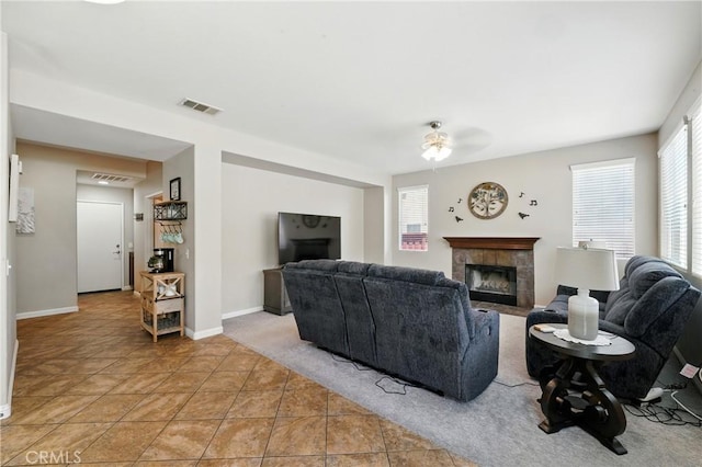 31258 Shadow Ridge Dr, Menifee, CA 92584 - living room with a tiled fireplace, healthy amount of natural light, light tile patterned floors, and a ceiling fan