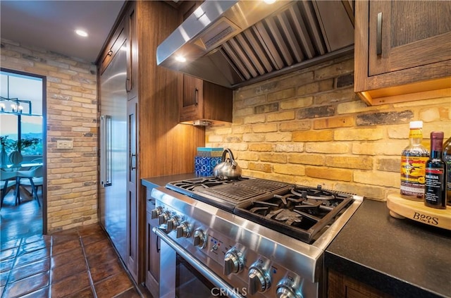 1960 Polaris Dr, Glendale, CA 91208 - kitchen with high end stainless steel range oven, wall chimney range hood, brick wall, dark countertops, and brown cabinetry