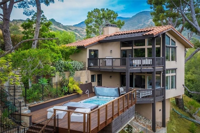 1960 Polaris Dr, Glendale, CA 91208 - rear view of house featuring a chimney, a hot tub, a balcony, stucco siding, and a deck with mountain view