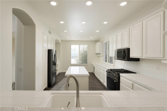 3120 Tara, Costa Mesa, CA 92626 - kitchen with black microwave, gas range oven, tile counters, recessed lighting, and white cabinets