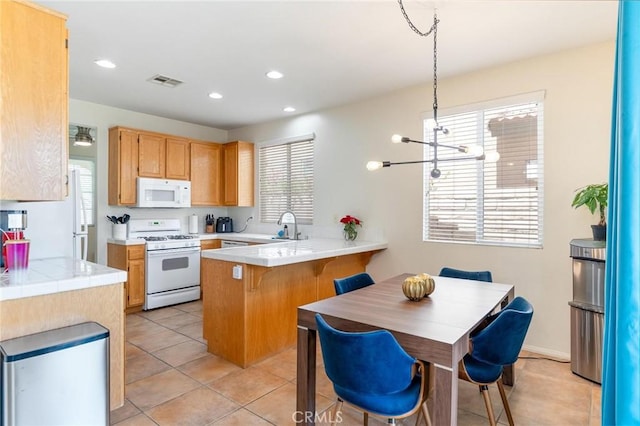 67760 Rio Vista Dr, Cathedral City, CA 92234 - kitchen featuring white appliances, a peninsula, a chandelier, light tile patterned floors, and recessed lighting