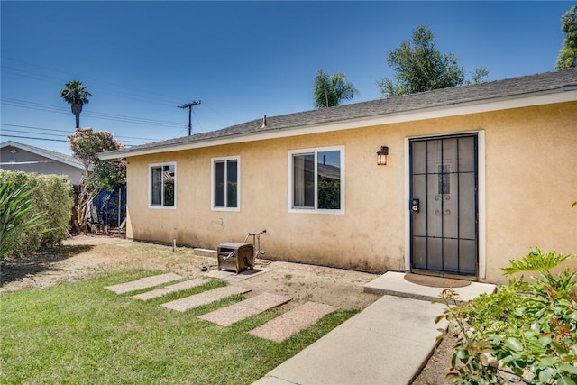 131 N Dommer Ave, Walnut, CA 91789 - rear view of property with stucco siding, a yard, and roof with shingles