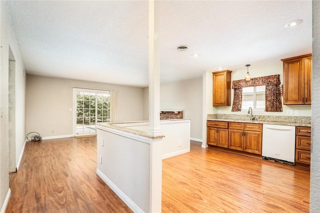 131 N Dommer Ave, Walnut, CA 91789 - kitchen featuring dishwasher, light wood-style flooring, brown cabinets, light stone counters, and decorative light fixtures