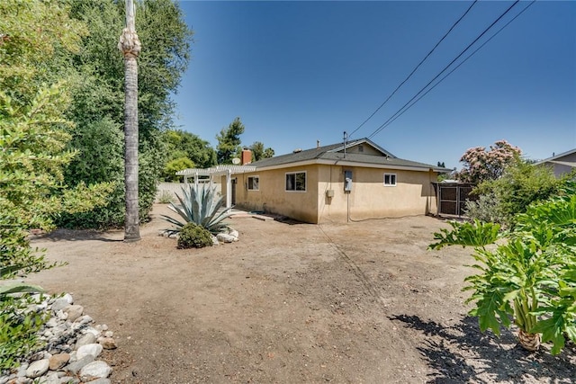 131 N Dommer Ave, Walnut, CA 91789 - rear view of house featuring stucco siding, a patio, a gate, and a chimney