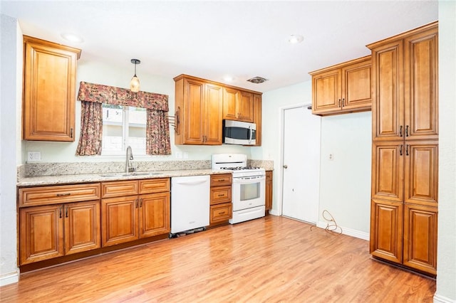131 N Dommer Ave, Walnut, CA 91789 - kitchen with white appliances, brown cabinetry, light wood-style floors, light stone counters, and recessed lighting