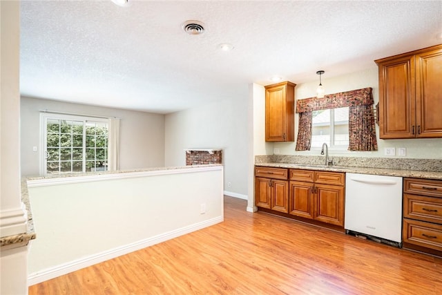 131 N Dommer Ave, Walnut, CA 91789 - kitchen featuring white dishwasher, light wood-style flooring, brown cabinetry, healthy amount of natural light, and a textured ceiling