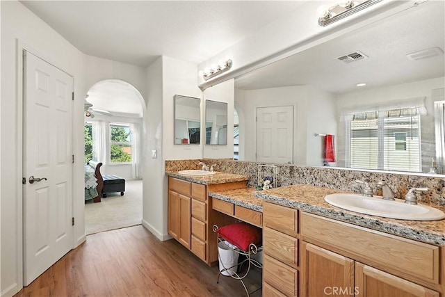 9790 Heatherhearst Dr, Chowchilla, CA 93610 - ensuite bathroom with double vanity, wood finished floors, and ceiling fan