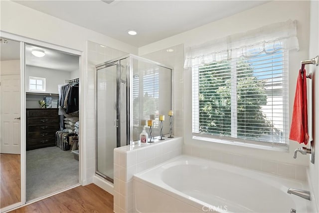 9790 Heatherhearst Dr, Chowchilla, CA 93610 - bathroom with a garden tub, a stall shower, wood finished floors, and a spacious closet