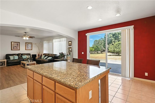 9790 Heatherhearst Dr, Chowchilla, CA 93610 - kitchen featuring a kitchen island, light tile patterned floors, arched walkways, recessed lighting, and ceiling fan