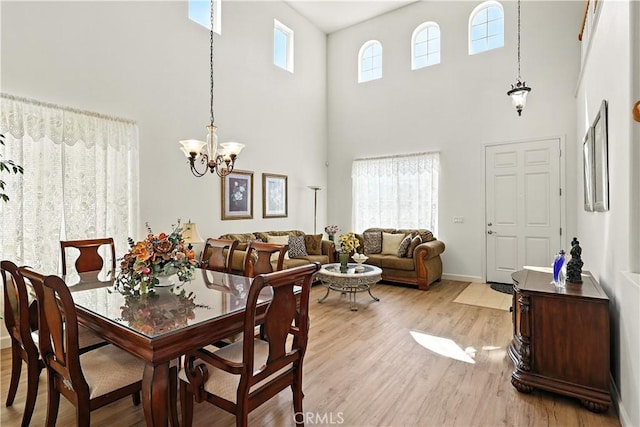 9790 Heatherhearst Dr, Chowchilla, CA 93610 - dining room featuring a towering ceiling, a chandelier, and light wood finished floors