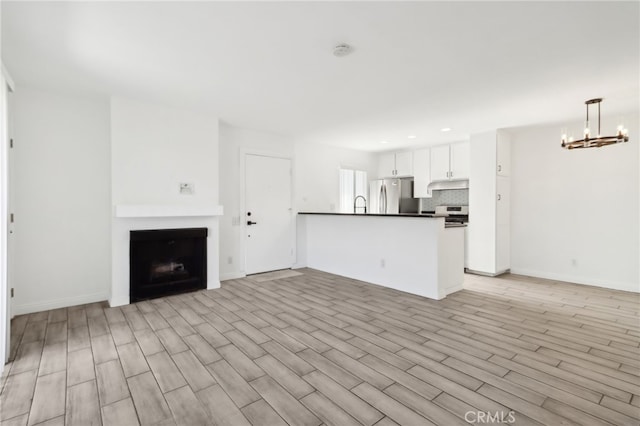 2827 S Fairview St Unit O, Santa Ana, CA 92704 - unfurnished living room with a chandelier, light wood-style floors, a fireplace, and recessed lighting