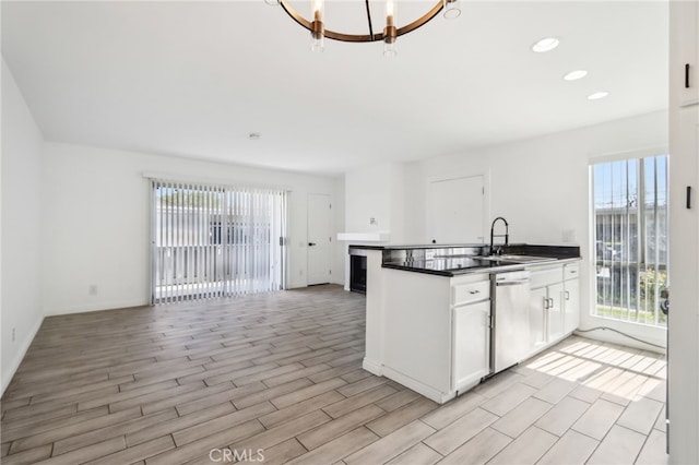2827 S Fairview St Unit O, Santa Ana, CA 92704 - kitchen featuring stainless steel dishwasher, healthy amount of natural light, dark countertops, white cabinetry, and recessed lighting