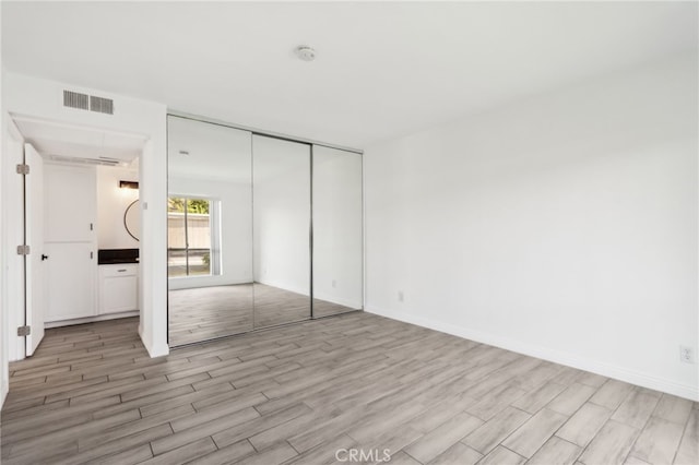2827 S Fairview St Unit O, Santa Ana, CA 92704 - unfurnished bedroom with light wood finished floors and a closet