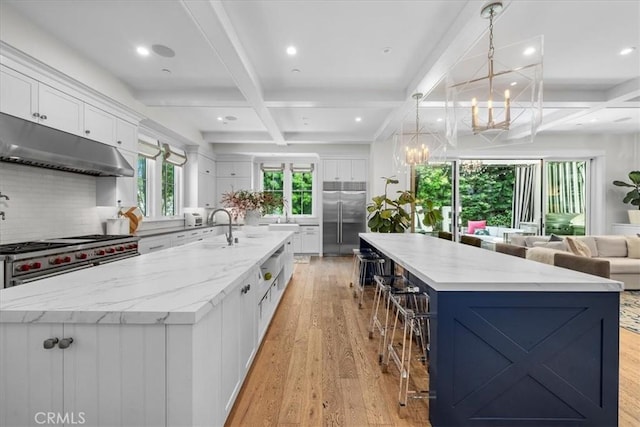 910 28th St, Manhattan Beach, CA 90266 - kitchen featuring high end appliances, a large island, coffered ceiling, under cabinet range hood, and light wood-type flooring
