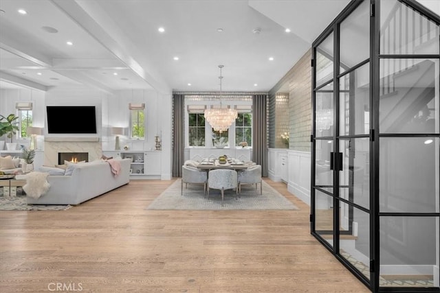 910 28th St, Manhattan Beach, CA 90266 - dining area featuring wood finished floors, a chandelier, a premium fireplace, a decorative wall, and recessed lighting