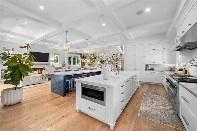 910 28th St, Manhattan Beach, CA 90266 - kitchen featuring appliances with stainless steel finishes, a large island with sink, coffered ceiling, tasteful backsplash, and open floor plan
