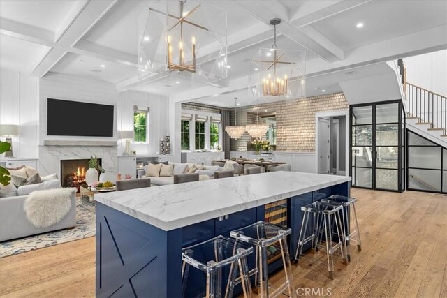 910 28th St, Manhattan Beach, CA 90266 - kitchen featuring coffered ceiling, a chandelier, light wood-type flooring, a center island, and a high end fireplace