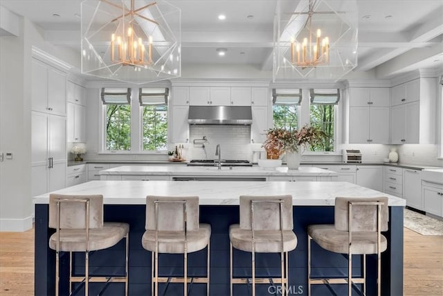 910 28th St, Manhattan Beach, CA 90266 - kitchen with a chandelier, under cabinet range hood, a kitchen island, healthy amount of natural light, and coffered ceiling