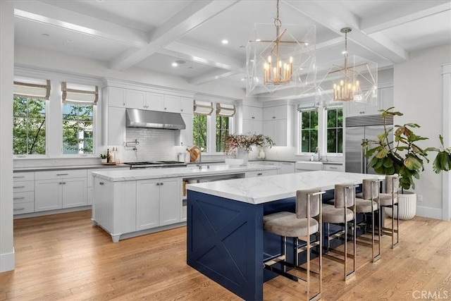 910 28th St, Manhattan Beach, CA 90266 - kitchen with a center island, under cabinet range hood, coffered ceiling, a chandelier, and stainless steel appliances