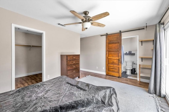 5616 Cahuilla Ave Unit 29, Palms, CA 92277 - bedroom featuring wood finished floors, a closet, a barn door, connected bathroom, and ceiling fan