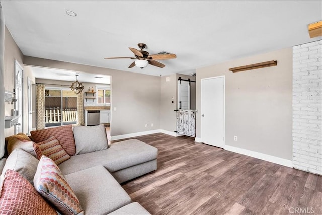 5616 Cahuilla Ave Unit 29, Palms, CA 92277 - living room with a barn door, wood finished floors, and ceiling fan