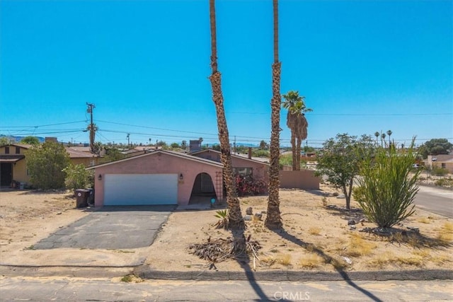 5616 Cahuilla Ave Unit 29, Palms, CA 92277 - view of front of property featuring a garage, stucco siding, and driveway
