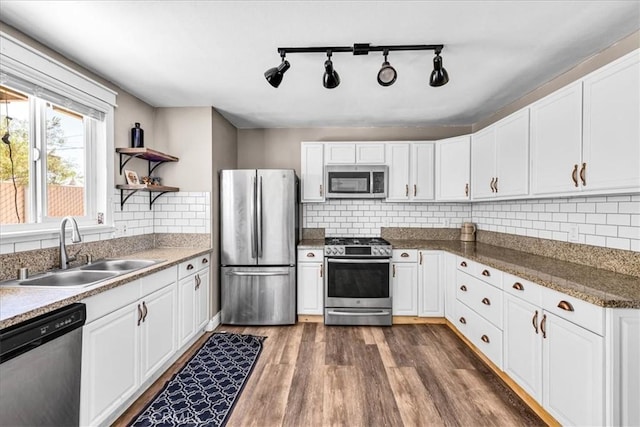 5616 Cahuilla Ave Unit 29, Palms, CA 92277 - kitchen with stainless steel appliances, dark wood-style flooring, white cabinetry, and decorative backsplash