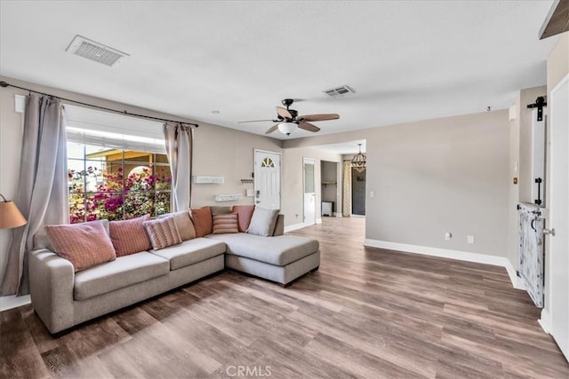 5616 Cahuilla Ave Unit 29, Palms, CA 92277 - living area featuring wood finished floors, ceiling fan, and a barn door
