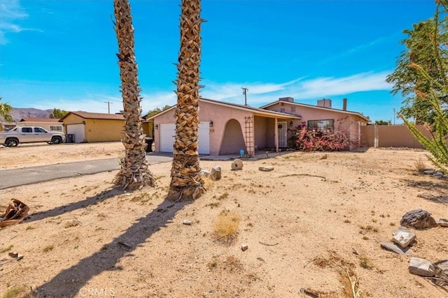 5616 Cahuilla Ave Unit 29, Palms, CA 92277 - view of front of house with a garage, stucco siding, and driveway