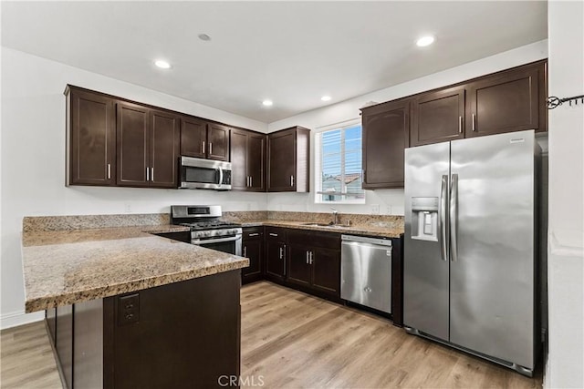 4429 La Joya Dr, Guadalupe, CA 93434 - kitchen with stainless steel appliances, dark brown cabinets, a peninsula, light wood-style flooring, and recessed lighting