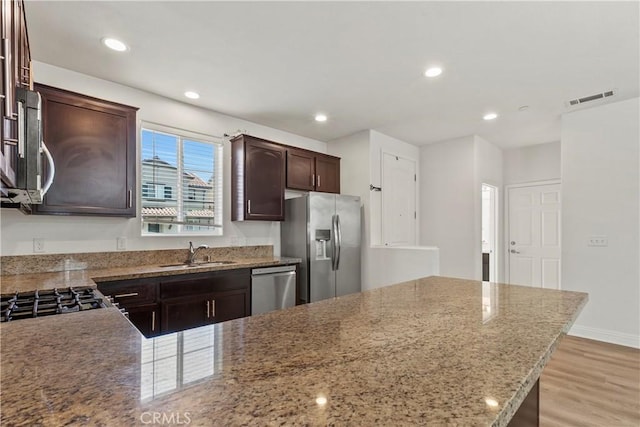 4429 La Joya Dr, Guadalupe, CA 93434 - kitchen featuring appliances with stainless steel finishes, dark brown cabinets, recessed lighting, light wood finished floors, and light stone countertops