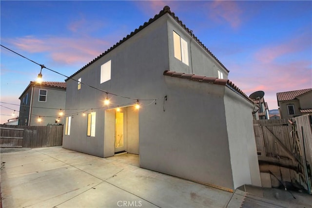 4429 La Joya Dr, Guadalupe, CA 93434 - back of house at dusk with a tiled roof, a patio area, and stucco siding