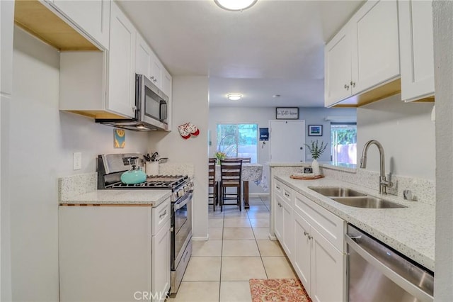 4863 Jackson St Unit B, Riverside, CA 92503 - kitchen featuring appliances with stainless steel finishes, light tile patterned floors, plenty of natural light, and white cabinetry