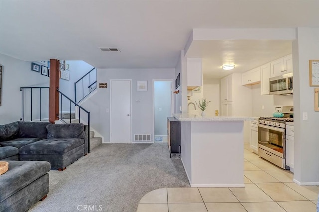 4863 Jackson St Unit B, Riverside, CA 92503 - kitchen featuring stainless steel appliances, open floor plan, white cabinets, a peninsula, and light stone counters