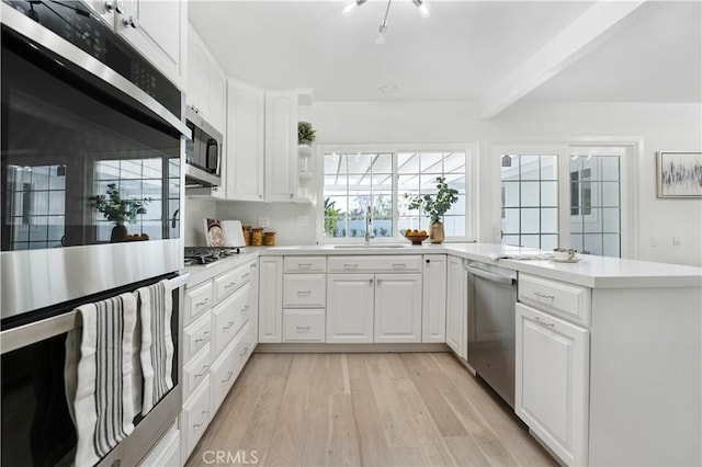 26342 Via Conchita, Mission Viejo, CA 92691 - kitchen featuring stainless steel appliances, light wood-style floors, light countertops, beamed ceiling, and white cabinets