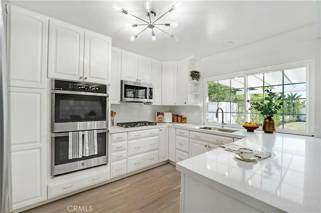 26342 Via Conchita, Mission Viejo, CA 92691 - kitchen featuring stainless steel appliances, a chandelier, light wood-style floors, white cabinetry, and light countertops