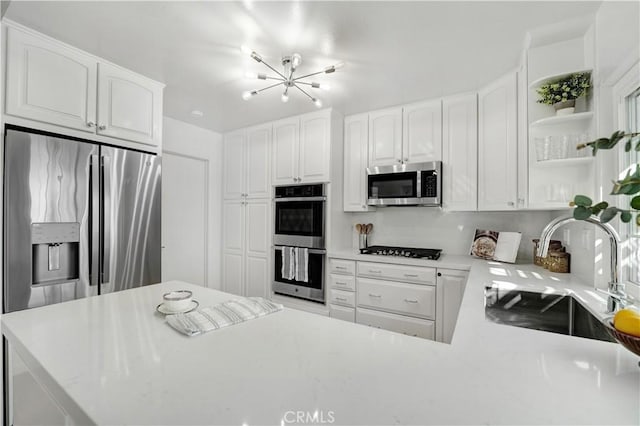 26342 Via Conchita, Mission Viejo, CA 92691 - kitchen with appliances with stainless steel finishes, a chandelier, open shelves, and white cabinets