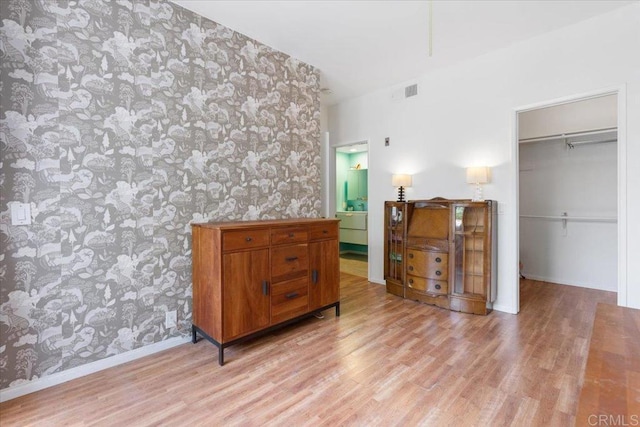 2224 River Run Dr Unit 154, San Diego, CA 92108 - bedroom featuring wallpapered walls, light wood-type flooring, and a walk in closet