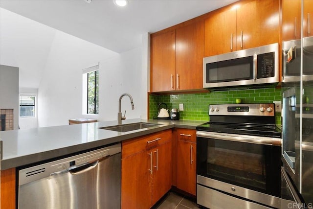 2224 River Run Dr Unit 154, San Diego, CA 92108 - kitchen featuring stainless steel appliances, decorative backsplash, brown cabinets, and dark tile patterned floors