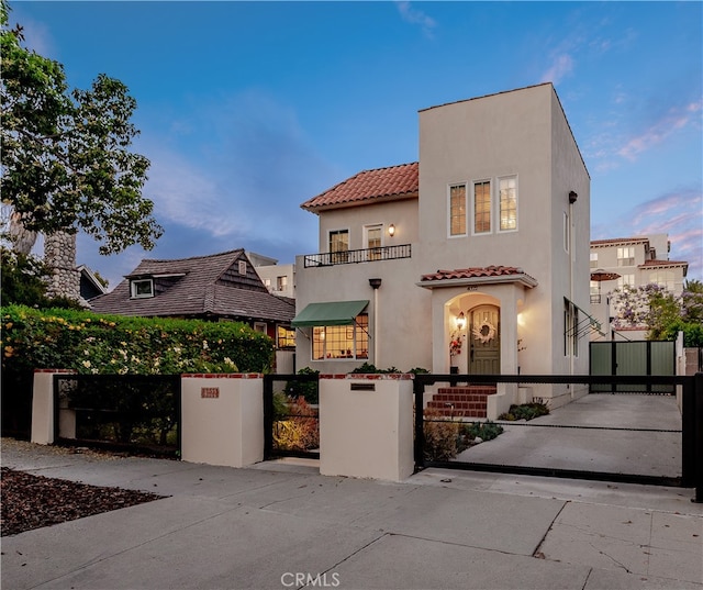 4022 Willowcrest Ave, Studio City, CA 91604 - view of front of home featuring a gate, a tiled roof, stucco siding, a fenced front yard, and a balcony